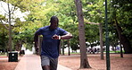 Fitness, smart watch or black man running in park to exercise for wellness, workout or marathon training. Nature, African runner or healthy athlete on jog or race with timer for progress or cardio