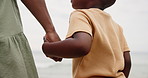 Mother, kid and holding hands on beach for support, bonding and holiday with closeup. Back of parent, mom or family with child by the ocean, sea or water in nature for love, care and explore together