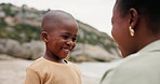 Mother, boy and talking at beach, happy and listening for advice, safety and care on holiday with love. Mom, child and conversation with connection, bonding and smile with black family on vacation