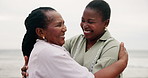 Happy, mother and daughter hug at beach with love and happiness on holiday or travel on vacation together. African, family and black woman embrace mature mom at ocean or sea with kindness and support