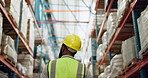 Man, walking and warehouse with helmet in logistics, supply chain or inventory inspection. Rear view of male person with hard hat in storage for checking stock, shelves or cargo in shipping industry