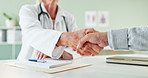 Doctor, prescription and handshake with patient for thank you, meeting or greeting at the clinic. Closeup of cardiologist or medical employee shaking hands with client for consultation or diagnosis