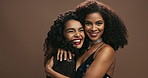 Happy woman, friends and hug with makeup in fashion for love, nightlife or support on a brown studio background. Portrait of female person or people with smile for beauty, care or style in friendship