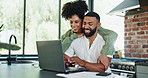 Couple, hug and laptop in home with paperwork, tax and results for loan application with smile in kitchen. Man, woman and happy with computer, embrace and documents for investment, finance or savings