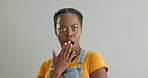 Face, surprise and black woman with omg, shocked and announcement on a grey studio background. Portrait, African person and model with reaction to a secret and gossip with emoji, wtf and fake news