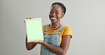 Face, green screen or happy black woman with tablet on grey background on social media in studio. Launch, mockup or confident African person with smile showing app promo, website or technology space