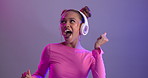 Woman, dancing and happy with headphones in studio or streaming entertainment or music, stress relief or listen. Female person, neon light and purple background or techno audio, glitter or mockup