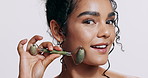 Woman, face and jade roller in studio for skin, dermatology and happy for self care by white background. Girl, person or model with pride for facial skincare, cosmetics and stone tools for massage