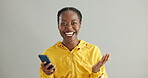 Woman, face and news for phone win in studio, excited and notification of prize giveaway. Black female person, portrait and app for online competition victory, lottery success and gray background
