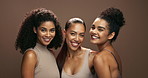 Women, face and group for beauty in studio for smile, solidarity or care with hug for skin by brown background. Girl friends, people and model for skincare, hug or natural makeup for facial cosmetics