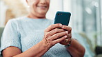 Senior, woman and hands typing with phone for communication, social media or networking on sofa at home. Closeup of elderly female person with smile on mobile smartphone in online chatting or texting
