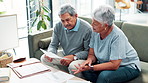 Senior couple, sofa and discussion with documents for finance, budget planning or exoduses at home. Elderly man and woman talking with financial paperwork for insurance or retirement plan at house