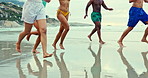 People, diversity and playing with water splash on beach for fun holiday, weekend or summer vacation. Group of diverse friends running and enjoying outdoor nature or freedom on the ocean coast or sea
