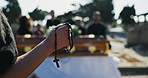 Person, hands and cross with coffin at cemetery for praying, Christianity or faith in ceremony of loss. Closeup of priest or prayer holding rosary beads at funeral for god, worship or forgiveness