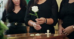 Hands, church or family by coffin with flowers at memorial service for respect, support and comfort. Funeral, closeup or sad people with roses, ceremony and goodbye at a casket for death or farewell
