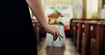 Funeral, hand and woman in church with flower at memorial service at coffin for respect, support and comfort. Death, grief and widow with rose, memory and goodbye at casket for spiritual farewell.