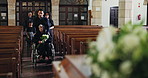 Grief, family and old woman in wheelchair at funeral together for memorial service at church for respect, support and comfort. Death, chapel and men and widow with memory, loss and spiritual farewell
