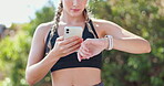 Woman, fitness and watch with smartphone in park for workout, exercise and tracking time. Female athlete, training and technology outdoors for heart rate, sports and check for progress in nature