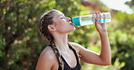 Woman, relax and workout in nature with drinking water for hydration, tired and deep breathing with fitness. Runner, athlete or liquid break for exercise, running or training outdoor for healthy body