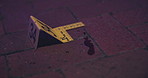 Crime scene, investigation and blood on floor for evidence, forensics and dna for pathology research. Marker, security and yellow sign with number for warning, caution and incident on red bricks