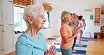 Senior woman, fitness and yoga class with prayer hands for spiritual wellness or balance together. Elderly people, yogi and coaching in meditation or pose for awareness or indoor exercise on mat