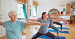 Elderly woman, stretching and pilates with yoga class for spiritual wellness or balance together. Senior people, yogi and coaching in zen, fitness or warrior pose for awareness or indoor exercise