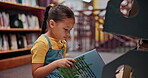 Reading book, child or girl in a library for a story in school campus for education on bookshelf. Smile, learning or smart kid student with scholarship studying knowledge, research or information