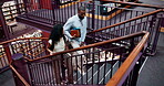 University, student and library walking with books for information, learning and knowledge for academic citation. Study group, education resources and research literature and stair for collaboration