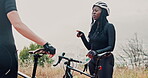 Cyclist, athlete and woman talking in nature with bicycle or bike for sports, training and exercise. Forest, fitness and people in woods for workout in environment together as friends and active