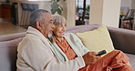 Smile, senior couple and watching tv in home living room together, talking and interracial people relax on couch. Television, elderly man and happy woman on sofa for show, news and streaming movie
