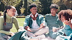Students, happiness and relax at university with conversation on break, diversity and bonding with communication. Funny, friends and grass or field on campus for study group with books and education