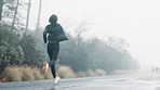 Woman, running and mountain for workout exercise in raining weather for marathon training, fitness or discipline. Female person, shoes and cardio sports in nature park for routine, athlete or outdoor