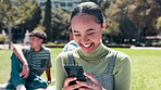 Happy woman, student and laughing with phone for social media, communication or networking at outdoor park. Female person with smile on mobile smartphone for online chatting on grass field in nature