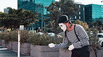 Mime, creativity and man in city with paint on face for performance, action and comedy outdoor. Artist, art and comic acting in urban street, drama or show for entertainment with mask for fun