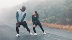 Man, woman and running stretching on mountain for exercise warm up in cold weather, training or marathon. People, legs and winter cardio on nature path in mist for sport fitness, routine or outdoor