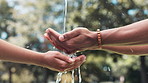 People, hands and water with hydration in nature for hygiene or natural sustainability at park. Closeup of liquid drops, cleansing or washing for healthcare, wellness or outdoor cleanliness in forest