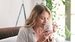 Woman, smile and break with coffee, relax and rest at home or apartment living room. Lady, window and peace for cappuccino, espresso and calm for breakfast for happiness on sofa in lounge or house
