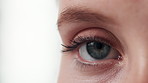 Blinking, half and eye for health of vision, closeup and sight for looking in white background. Studio, person and adult with cosmetics of microblading of eyebrow on face with care for beauty