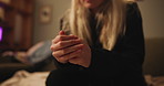 Hands, anxiety and nervous woman on a sofa with fear, danger or overwhelmed by mental health crisis at home closeup. Fingers, stress and female person in a living room overthinking, scared or panic