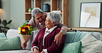 Old man, woman and surprise of flowers on couch or sofa, happy and couple in living room of house. Senior, male person and partner with gift for love, smile and happiness in home and retirement