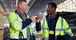 Fist bump, teamwork and men walking in warehouse for construction, distribution and maintenance. Civil engineering, factory and people with greeting for logistics, infrastructure and manufacturing