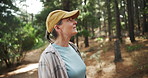 Hiking, thinking or mature woman in nature, woods or wilderness for trekking or outdoor adventure. Smile, relax or hiker walking in park, forest or Norway for exercise or wellness on holiday vacation
