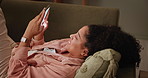 Home, relax and woman on a sofa, cellphone or typing with social media or texting a contact. Person on a couch, apartment or girl with smartphone, connection or message with funny meme or digital app