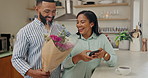 Man, woman and flowers for surprise in kitchen for marriage anniversary, gift and hug with love in home. Happy couple, embrace and floral bouquet with phone, connection and bonding on Valentines Day