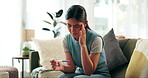 Woman, pregnancy test and stress in home or anxiety for infertility results or pregnant bad news, unhappy or grief. Female person, stick and health risk in lounge for future doubt, scared or mistake