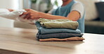 Laundry, clean clothing and pile of washing, fold or cleaning for household chores. Hands, linen or fabric for spring clean in home lounge, housewife or housekeeper for sanitary hygiene or organising