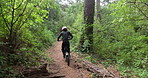 Man, forest and dirt bike with back for extreme sport, race and adventure on nature trail. Person, rider and motorcycle with speed by trees on outdoor path in competition, contest or journey in woods