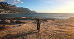 Persone, motorbike and riding by beach for travel, adventure  and off road training or extreme sports. Back of a biker with safety helmet and bike for journey and biking by ocean or sea in Cape Town