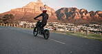 Person, road and motorbike in city for travel, adventure or riding with training in extreme sports. Back of a biker with safety helmet and bike for journey by coast, ocean or mountains in Cape Town