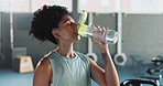 Fitness, drinking and woman with bottle of water in gym for health, wellness and hydration. Sports, exercise and young female person enjoying fresh aqua beverage for nutrition in workout center.
